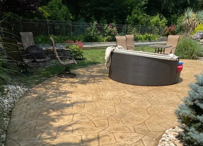 Stamped concrete pool deck with a slate tile pattern, enhancing the pool area with a durable and attractive surface.