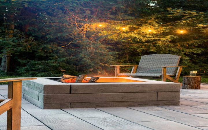A cozy outdoor living space featuring a modern masonry fireplace with a sleek concrete surround, perfect for evening gatherings.