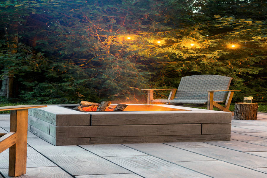 A cozy outdoor living space featuring a modern masonry fireplace with a sleek concrete surround, perfect for evening gatherings.